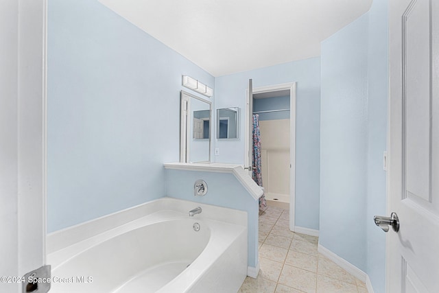 bathroom with tile patterned floors and a tub to relax in