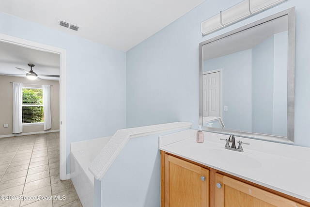 bathroom with tiled bath, vanity, ceiling fan, and tile patterned floors