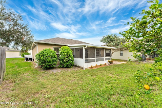 2122 Spring Creek Cir NE, Palm Bay, FL 32905 - back of house featuring a sunroom, a lawn, and stucco siding