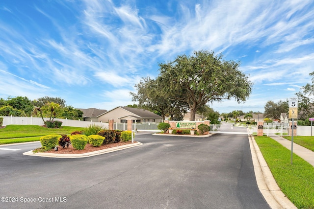 2122 Spring Creek Cir NE, Palm Bay, FL 32905 - view of asphalt street featuring a gate, curbs, a gated entry, and sidewalks