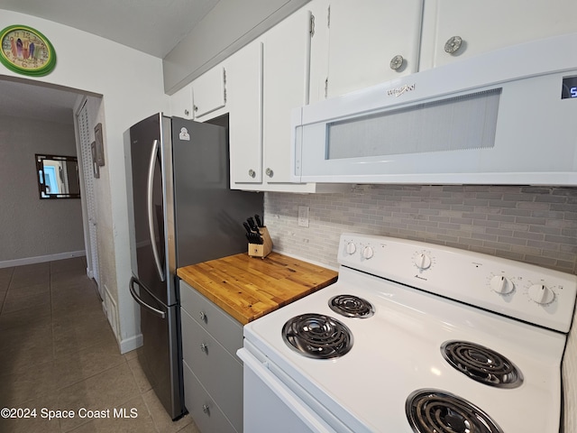 kitchen with white cabinets, tile patterned flooring, white appliances, and backsplash