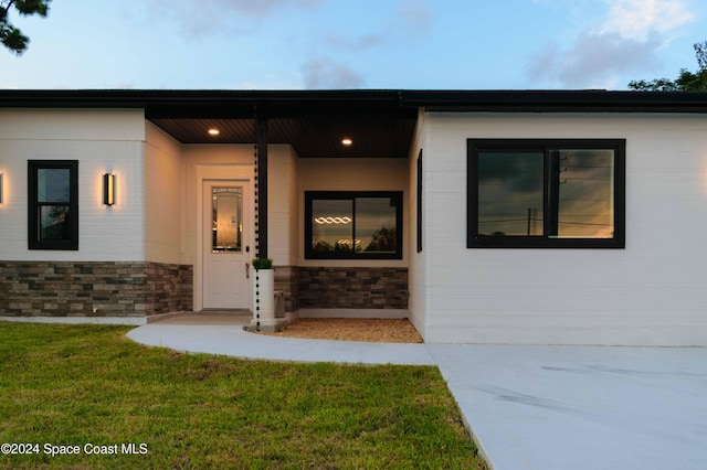 property entrance with a lawn