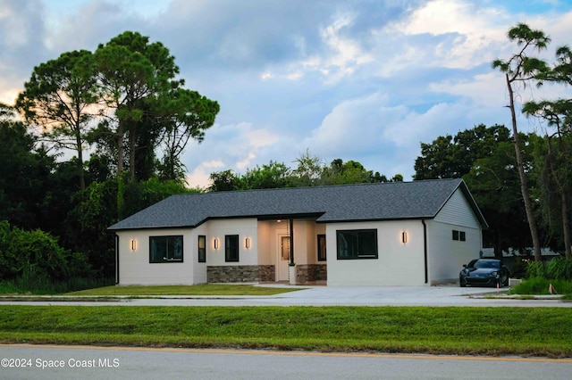 3470 W Eau Gallie Blvd, Melbourne, FL 32935 - view of front of home featuring stone siding, a front yard, and roof with shingles