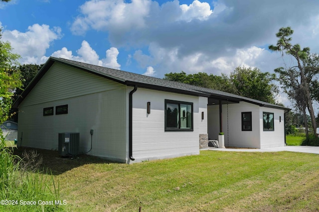 3470 W Eau Gallie Blvd, Melbourne, FL 32935 - rear view of property with central AC, a lawn, and a shingled roof