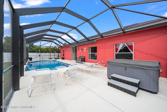 view of swimming pool with glass enclosure, a patio, and a hot tub