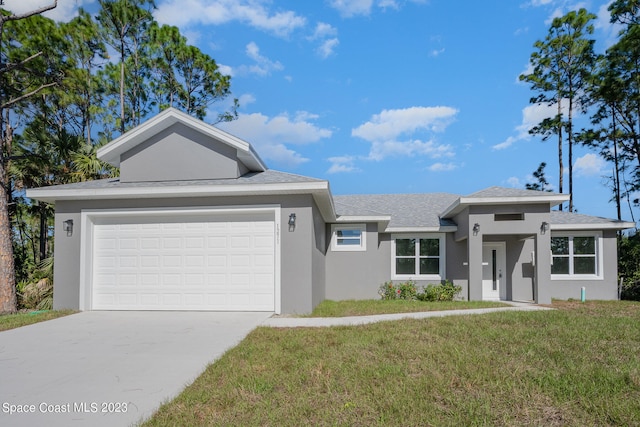 view of front of property featuring a front yard and a garage