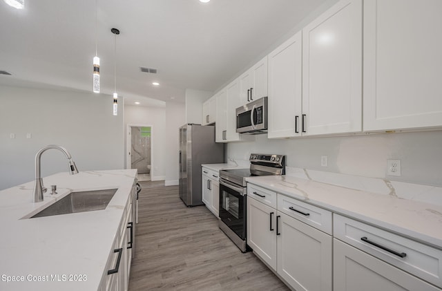 kitchen featuring white cabinets, sink, light wood-type flooring, and stainless steel appliances