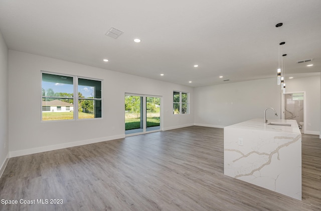 unfurnished living room featuring light hardwood / wood-style flooring and sink