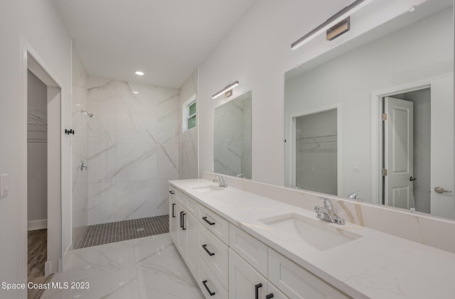 bathroom featuring tiled shower and vanity