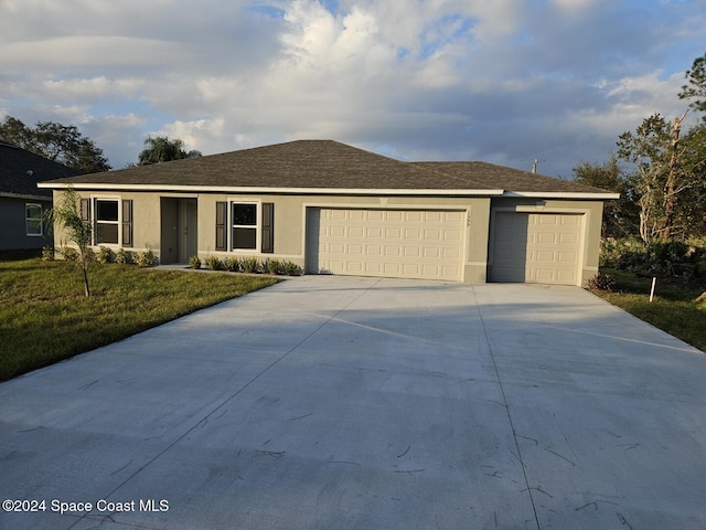 single story home featuring a front yard and a garage