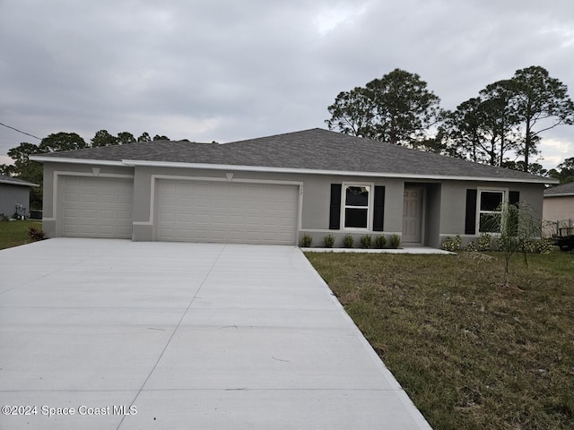 ranch-style house featuring a garage and a front yard