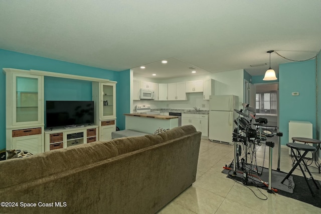 living room featuring sink and light tile patterned floors