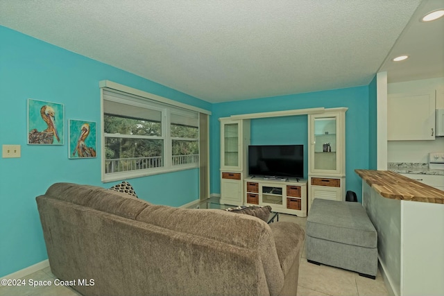 living room with a textured ceiling and light tile patterned flooring