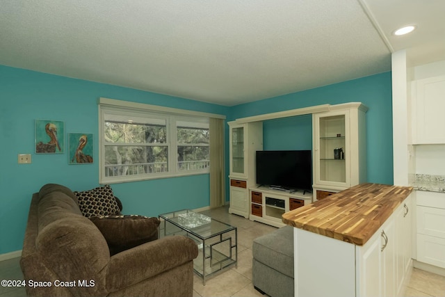 tiled living room featuring a textured ceiling