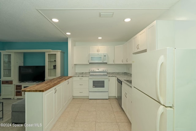 kitchen with light stone countertops, white cabinetry, light tile patterned flooring, and white appliances