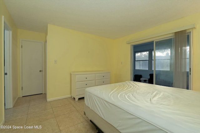 bedroom with access to outside and light tile patterned floors