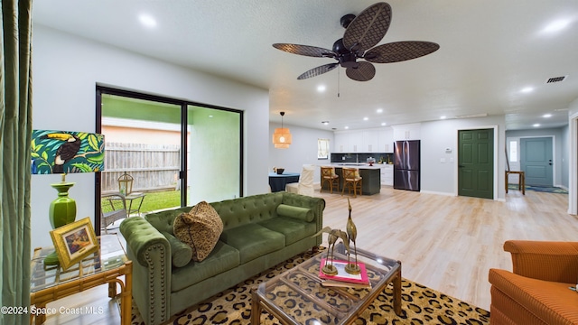 living room with light hardwood / wood-style floors and ceiling fan