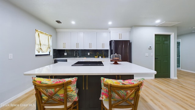 kitchen featuring a large island, white cabinets, and fridge