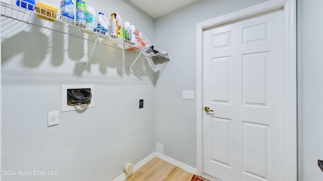 clothes washing area featuring hookup for an electric dryer, hardwood / wood-style flooring, and washer hookup