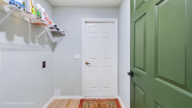 laundry area with hookup for an electric dryer and wood-type flooring