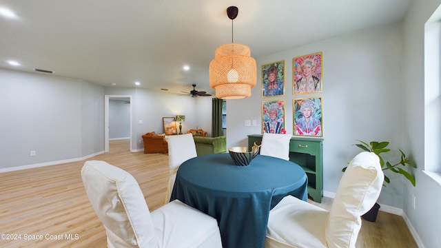 dining space with ceiling fan and light hardwood / wood-style flooring