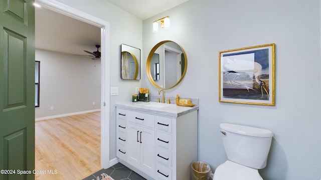 bathroom with hardwood / wood-style floors, ceiling fan, toilet, and vanity