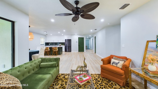 living room featuring light wood-type flooring and ceiling fan