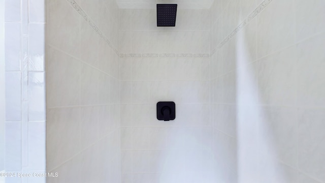 interior details featuring a tile shower