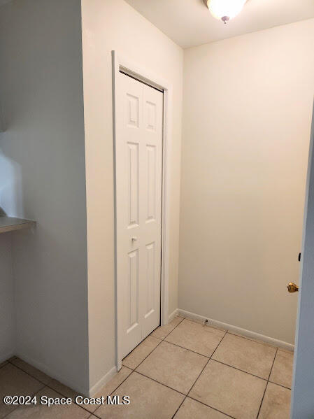 hallway featuring light tile patterned floors and baseboards