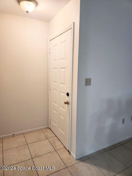 doorway featuring light tile patterned flooring and baseboards