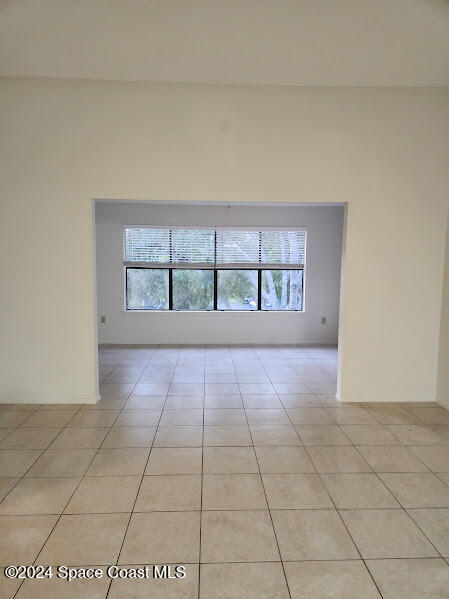 empty room with light tile patterned floors and a healthy amount of sunlight