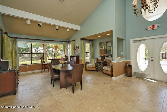 dining area featuring a chandelier, french doors, rail lighting, and baseboards