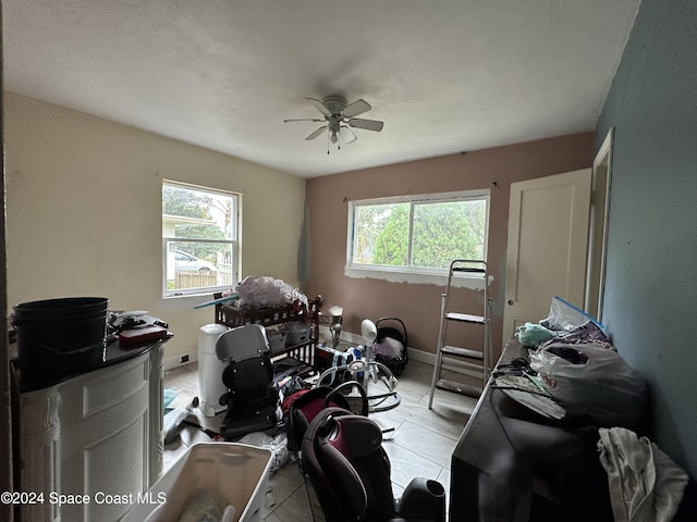 miscellaneous room featuring a wealth of natural light, ceiling fan, and light tile patterned floors