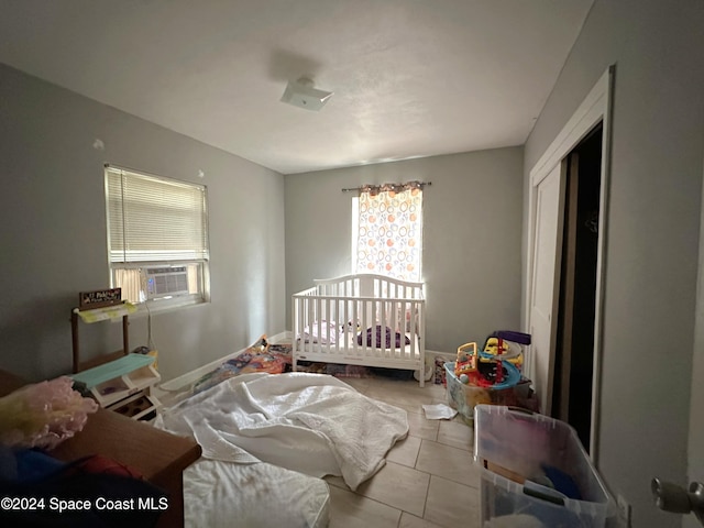 bedroom featuring cooling unit, a closet, and light tile patterned floors