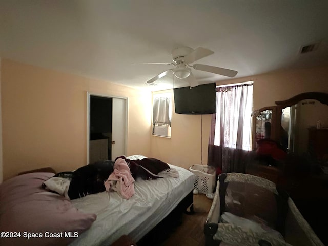 bedroom with ceiling fan, cooling unit, and dark hardwood / wood-style floors