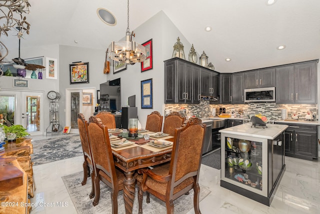 dining area featuring french doors, high vaulted ceiling, and a notable chandelier