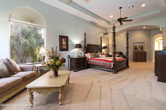 bedroom featuring ceiling fan, a raised ceiling, and light carpet