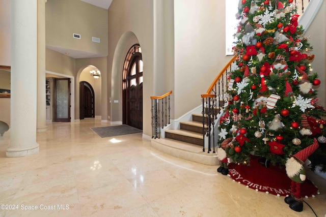 foyer with a towering ceiling and ornate columns