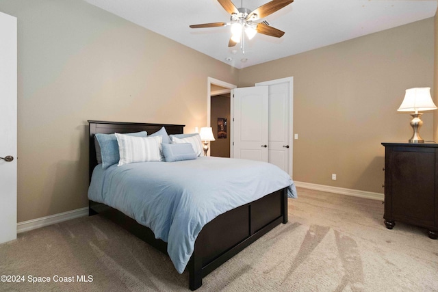 bedroom featuring ceiling fan, baseboards, and light colored carpet