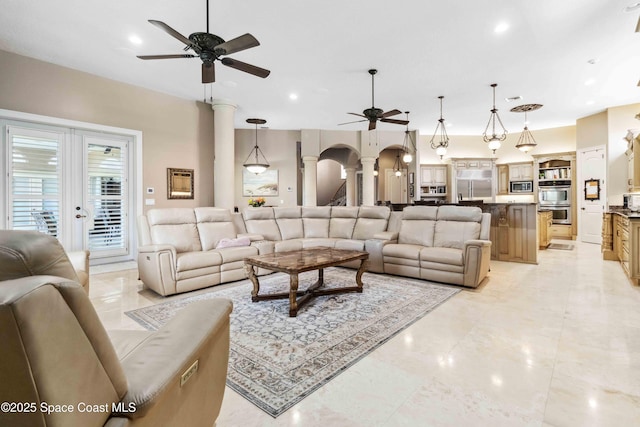 living room featuring a ceiling fan, arched walkways, ornate columns, and recessed lighting