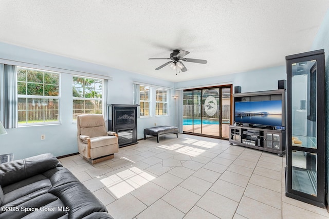 tiled living room featuring ceiling fan and a textured ceiling