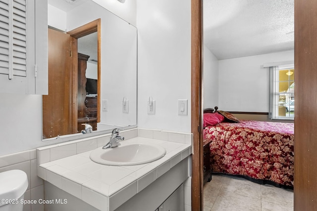 bathroom featuring a textured ceiling, toilet, and vanity