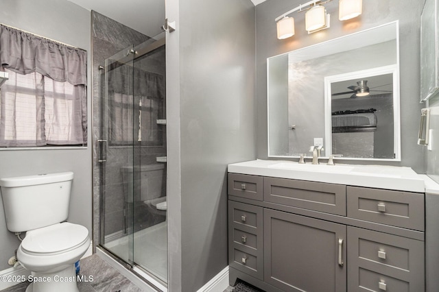 bathroom featuring vanity, a shower with shower door, ceiling fan, and toilet