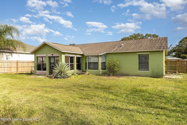 rear view of house with a lawn and a sunroom