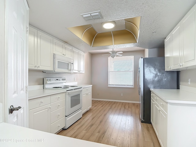 kitchen with a textured ceiling, white appliances, ceiling fan, light hardwood / wood-style flooring, and white cabinetry