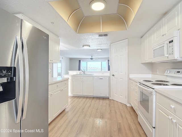 kitchen with a textured ceiling, white appliances, ceiling fan, light hardwood / wood-style flooring, and white cabinets