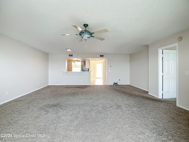 unfurnished living room featuring ceiling fan, carpet, and a textured ceiling