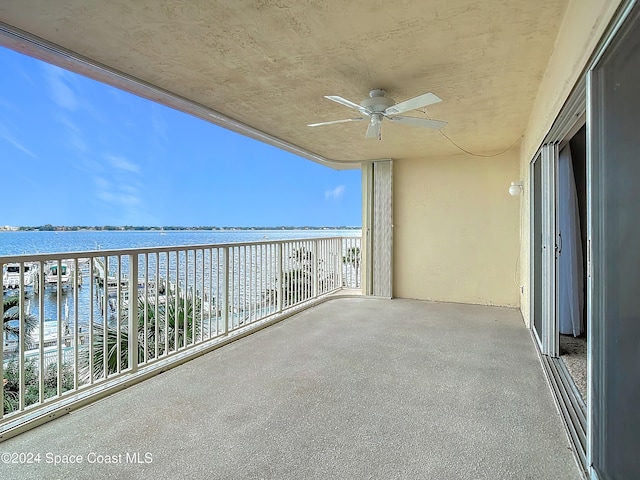 balcony with a water view and ceiling fan