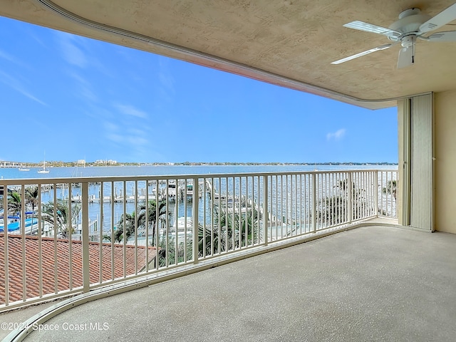 balcony featuring ceiling fan and a water view