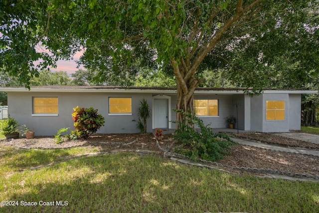 ranch-style home featuring a lawn